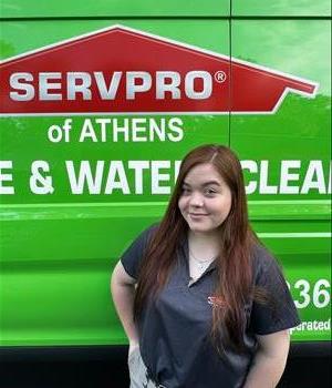 Kristin is smiling in front of a green van.